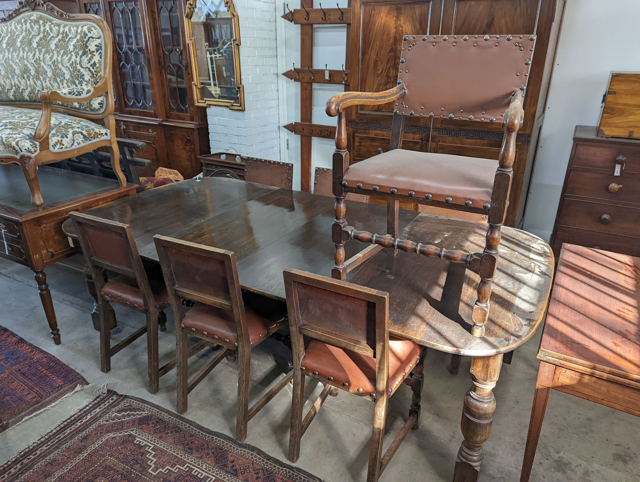 A 1920's oak extending dining table, 238cm extended (two spare leaves), width 120cm, height 74cm together with seven oak dining chairs (one with arms)